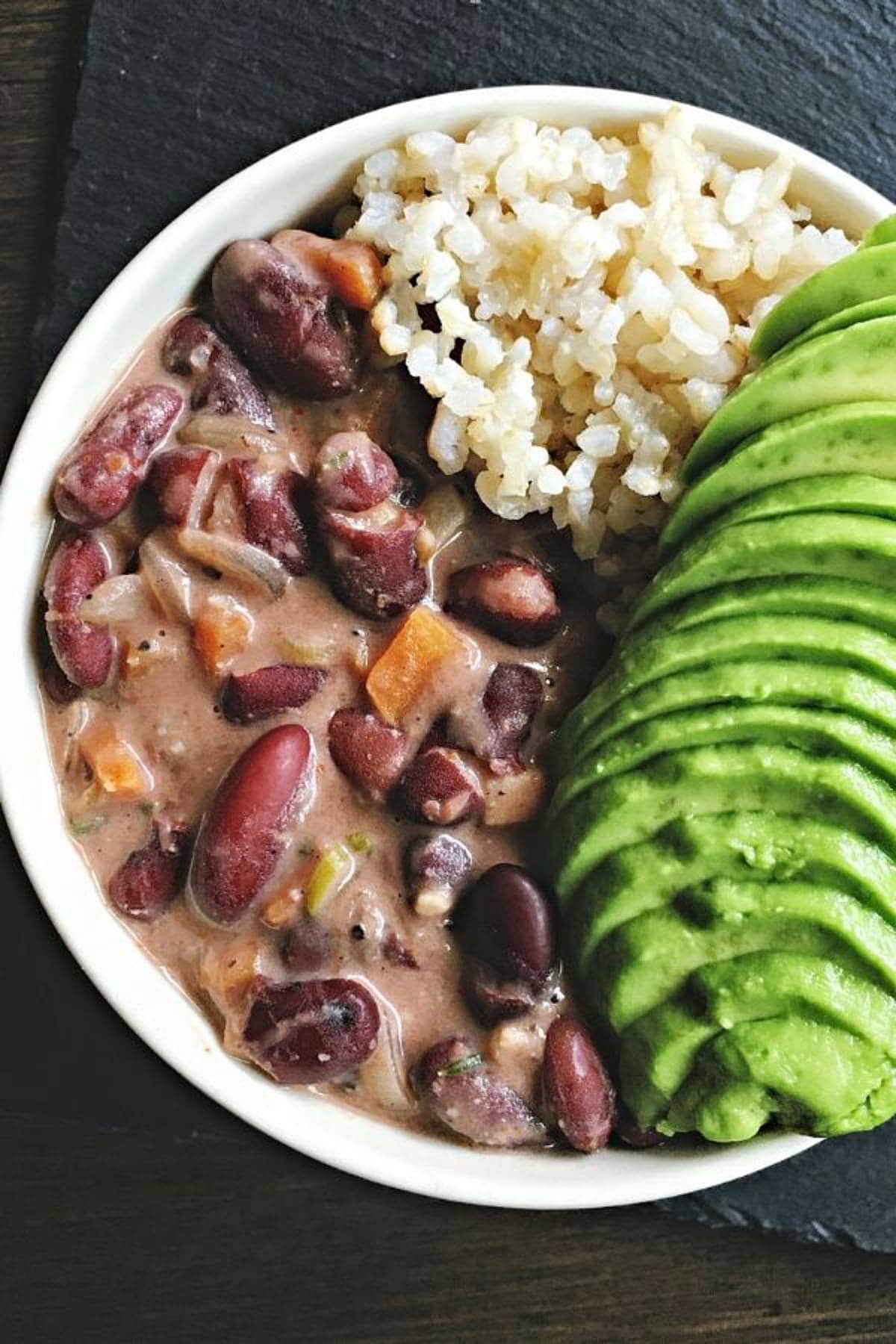 Vegan jamaican red bean stew with avocado and rice in a bowl