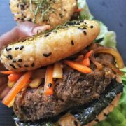 Hand holding rice bun burger with kimpira