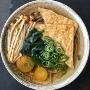 Vegan kitsune soba with aburaage and toppings in a bowl