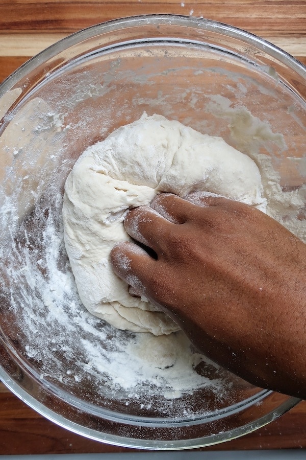 Hand kneading dough in a bowl