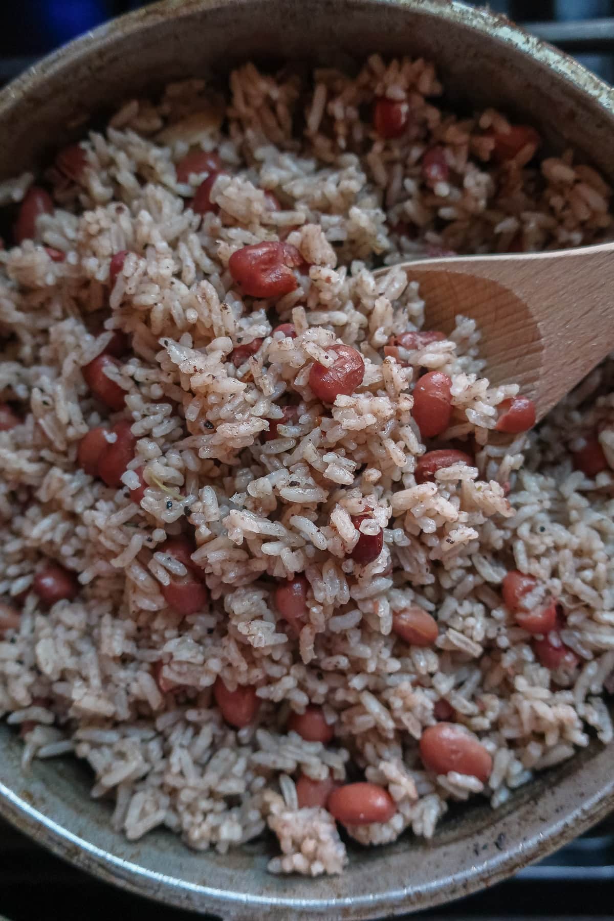 jamaican rice and peas in pot with wooden spoon