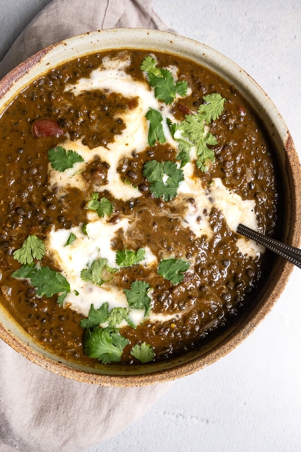 Black lentil curry and spoon in a bowl