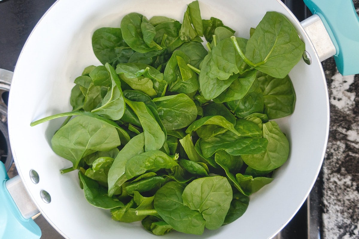 Fresh spinach in pot on stovetop