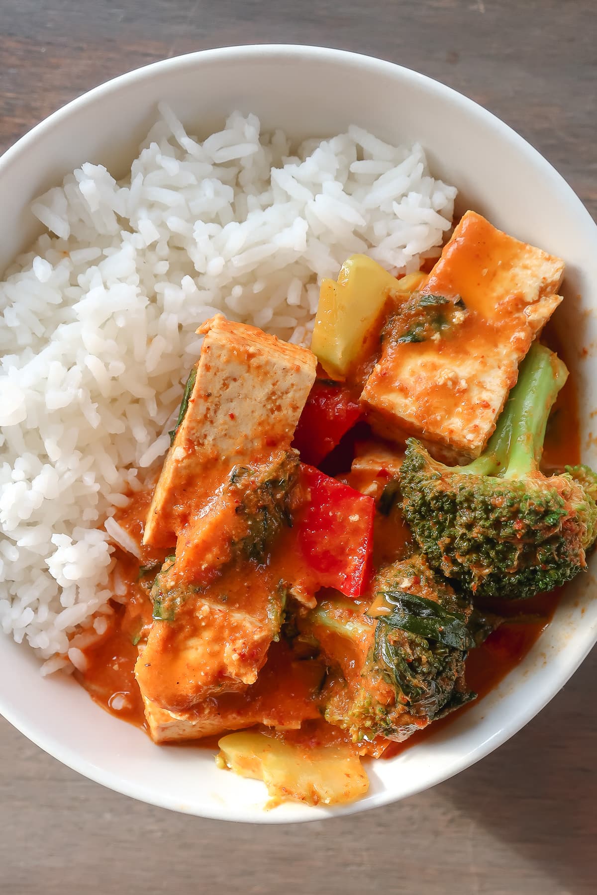 Red curry with tofu and vegetables in a bowl with rice