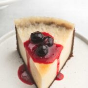 Slice of cheesecake with fruit topping on white plate