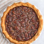 Pecan pie on table next to striped cloth