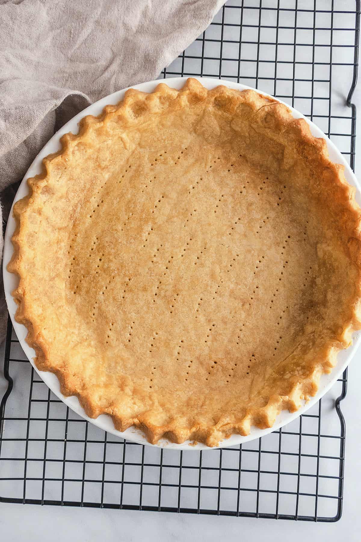Baked pie crust without filling on cooling rack.
