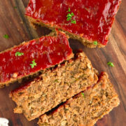 Close up of sliced vegan meatloaf on wooden cutting board.